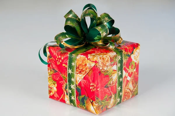 Πρωτοχρονιάτικο δώρο, σε εορταστική συσκευασία. κόκκινο κουτί με πράσινο κορδέλα. — Φωτογραφία Αρχείου