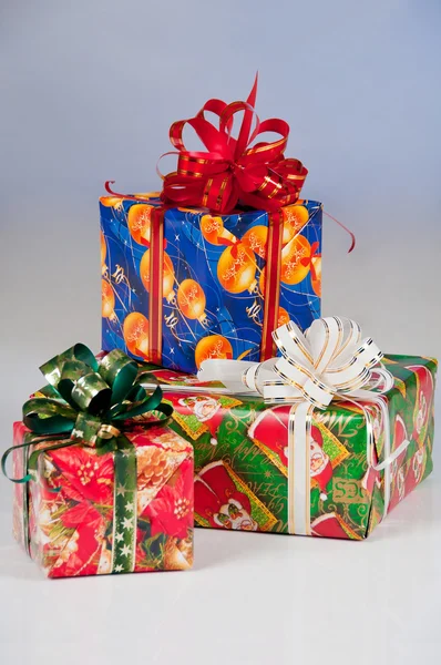 New Year's gifts in festive packaging. Red box with green ribbon, blue — Stock Photo, Image