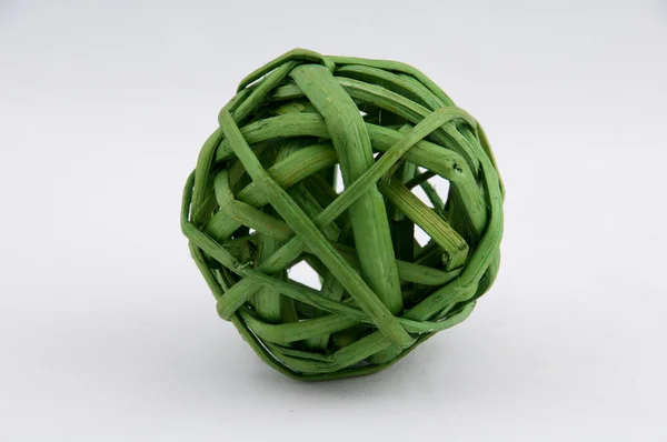 Bola decorativa verde hecha con mimbre sobre un fondo blanco — Foto de Stock