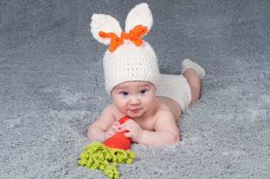 A small child with a rabbit ears. Lying on his stomach with a ca clipart