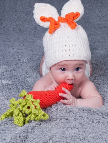 Un petit enfant avec des oreilles de lapin. Allongé sur le ventre avec un ca — Photo