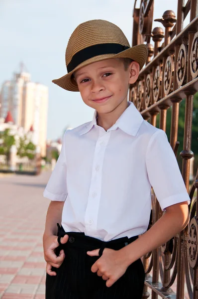 A little boy in a retro hat on a background of the city. Portrai — Stock Photo, Image