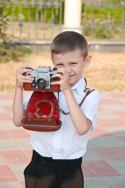 Мальчик с ретро-камерой — стоковое фото