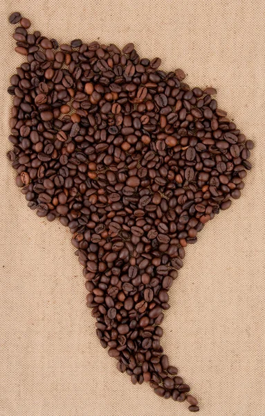 Les grains de café sont disposés sur le sac en forme d'Amérique du Sud — Photo