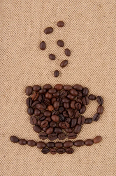 Une tasse de grains de café avec de la fumée sur le fond de toile de jute . — Photo