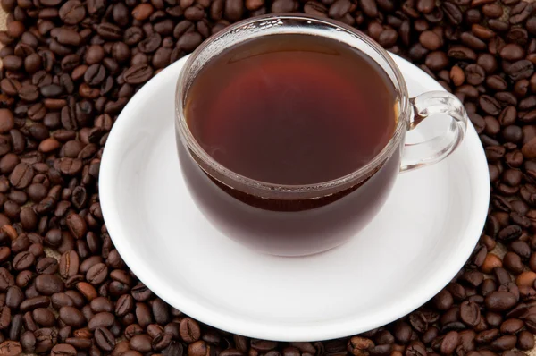 Une tasse de café sur le fond de grains de café — Photo