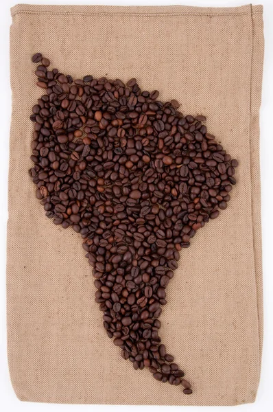 Les grains de café sont disposés sur le sac en forme d'Amérique du Sud — Photo