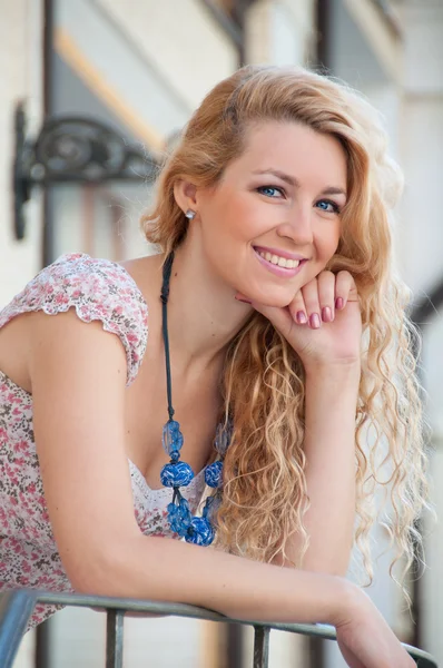 En vacker ung blond sexig kvinna står nära räcket. — Stockfoto
