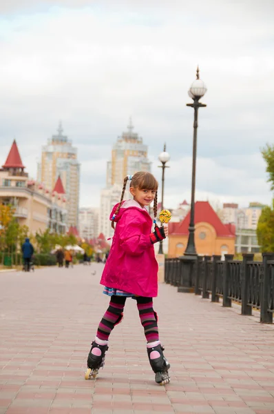 Een meisje op rolschaatsen naar beneden de weg. — Stockfoto