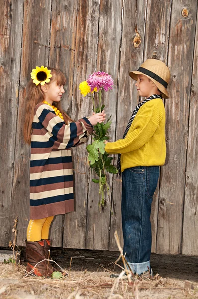 这个男孩给女孩带来了鲜花。第一次的爱. — 图库照片