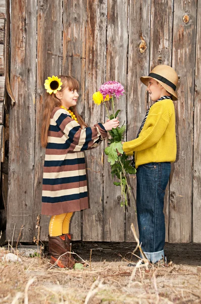 Chlapec dává dívce květiny. první láska. — Stock fotografie