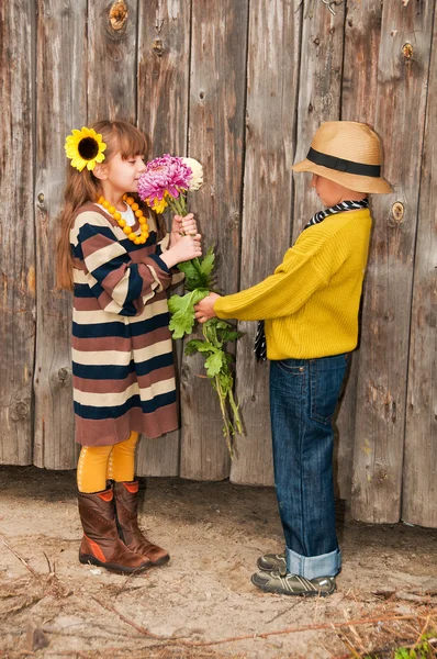De jongen geeft een meisje bloemen. eerste liefde. — Stockfoto