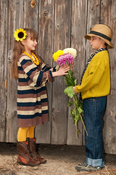 The boy gives a girl flowers. First love. — Stock Photo, Image