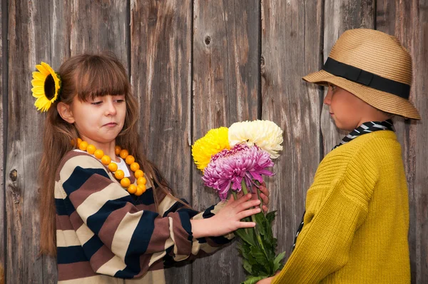 Il ragazzo regala dei fiori ad una ragazza. Primo amore . — Foto Stock