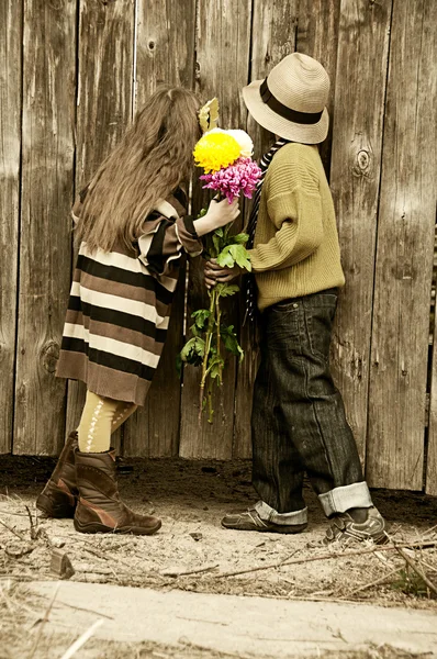 Il ragazzo con la ragazza sbircia oltre la recinzione. Foto nel vecchio stile . — Foto Stock