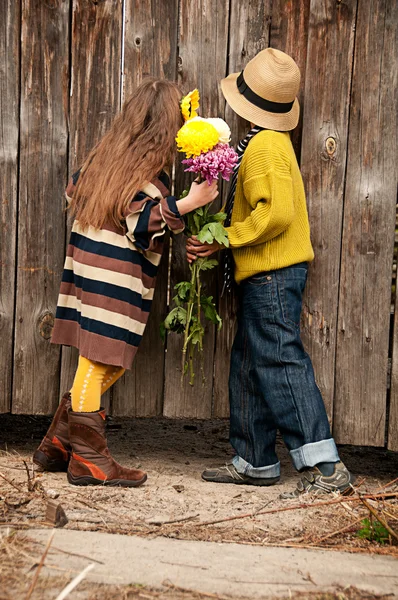 De jongen met de meisje peep over het hek. foto's in de oude stijl. — Stockfoto