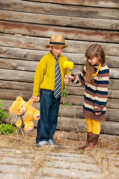 Le garçon avec la fille debout près d'une clôture en bois . — Photo