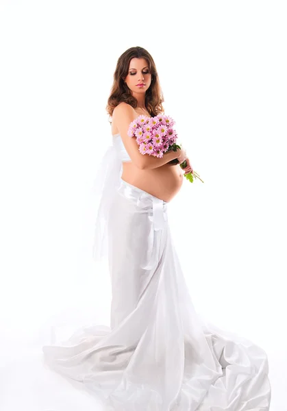 A imagem de uma mulher grávida com flores violetas isolado no wh — Fotografia de Stock