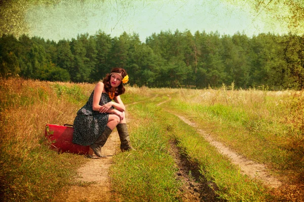 Mooie brunette met een koffer op het platteland. foto's in — Stockfoto