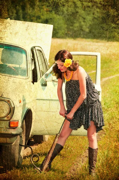Beautiful brunette car repairs. Photos in the old style. — Stock Photo, Image
