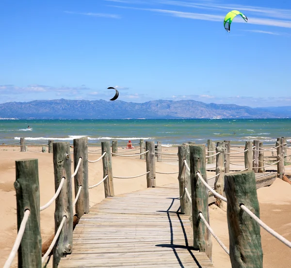 Escadas de madeira e kitesurfistas na praia Riumar Espanha — Fotografia de Stock