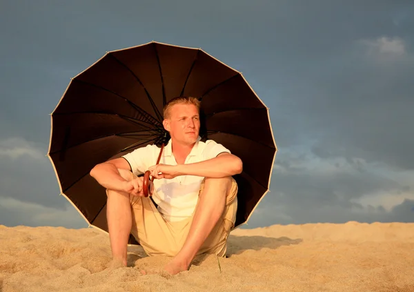 Hombre relajante con sombrilla en la playa Cerdeña Italia — Foto de Stock