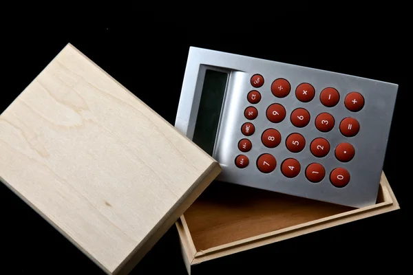 Wooden box and calculator — Stock Photo, Image