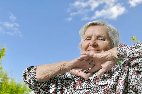 Senior woman on the blue sky — Stock Photo, Image