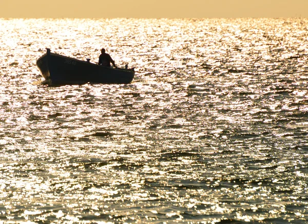 Fishermen returning from fishing on the background of the sun — Stock Photo, Image