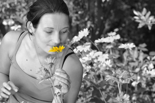 Kvinna att lukta blommor. — Stockfoto