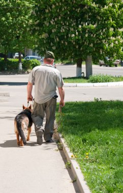 bir adam köpeğiyle yürüyor