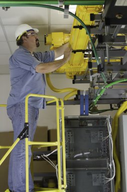 Telecommunication Switch Worker Inspecting Fiber Optic Run clipart