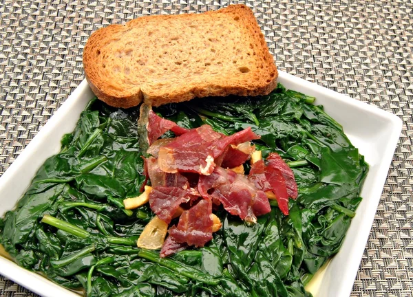 Spinach stew with ham and toast — Stock Photo, Image