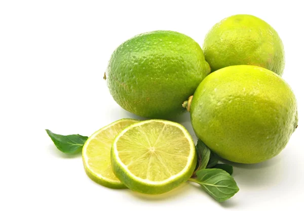 Several limes with lime slices — Stock Photo, Image