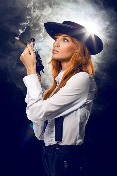 Hermosa chica con sombrero, con un revólver — Foto de Stock