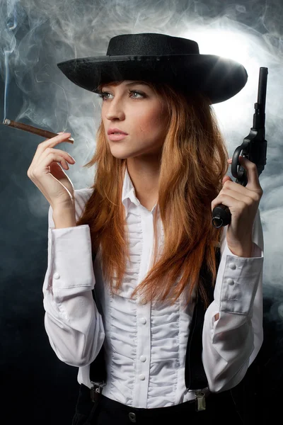 Das schöne Mädchen mit Hut, mit einem Revolver lizenzfreie Stockfotos