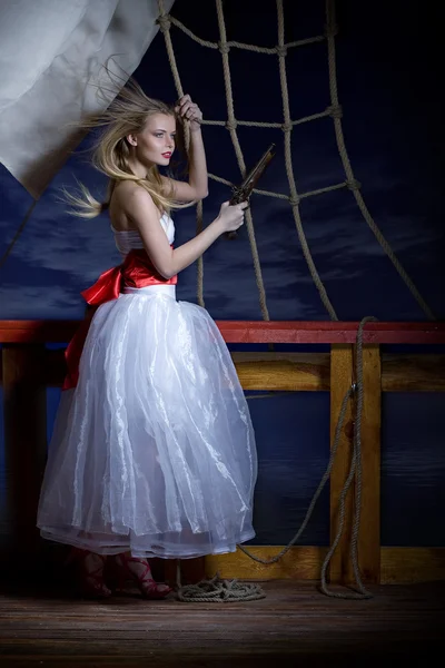 Vacker flicka i en vit klänning på en kortlek med segelfartyget. — Stockfoto