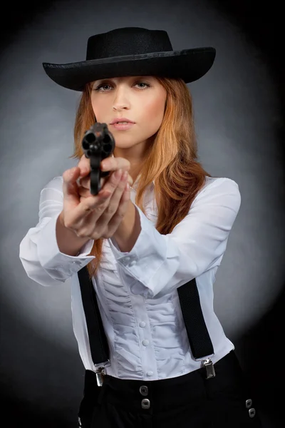 Menina bonita em chapéu, cabelo vermelho, com revólver nas mãos . — Fotografia de Stock
