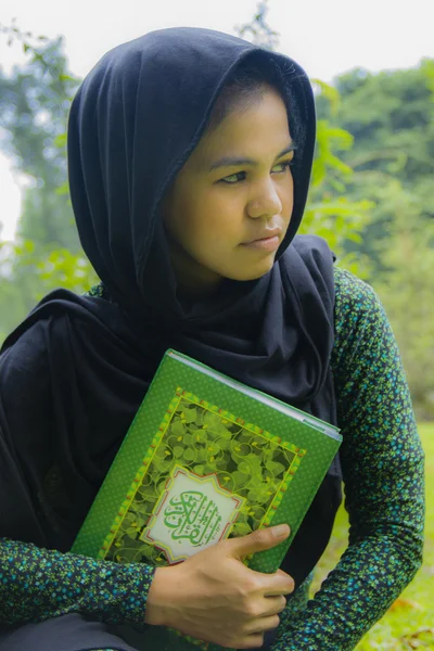 Indonesian girl holding quran — Stock Photo, Image
