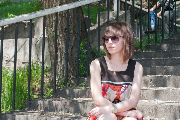 Молодая девушка сидит на ступеньках — стоковое фото