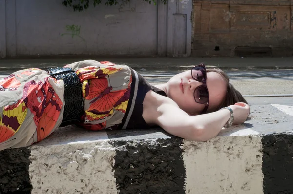 Das schöne Mädchen liegt auf einer Betonplatte — Stockfoto