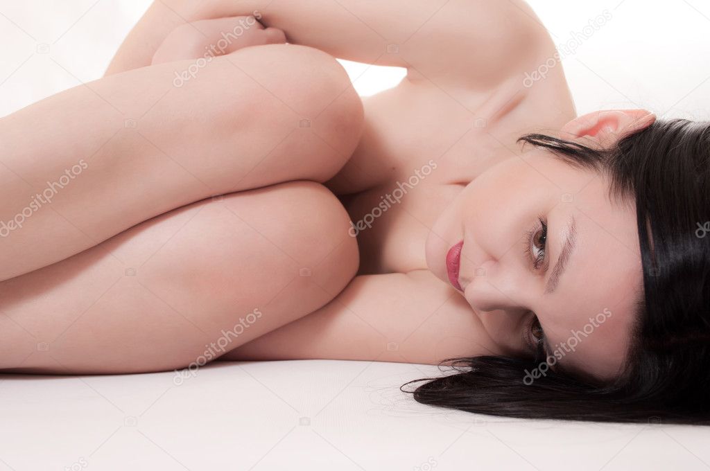 The naked girl lies on a white background