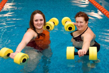 Mum with a daughter in aqua aerobics clipart