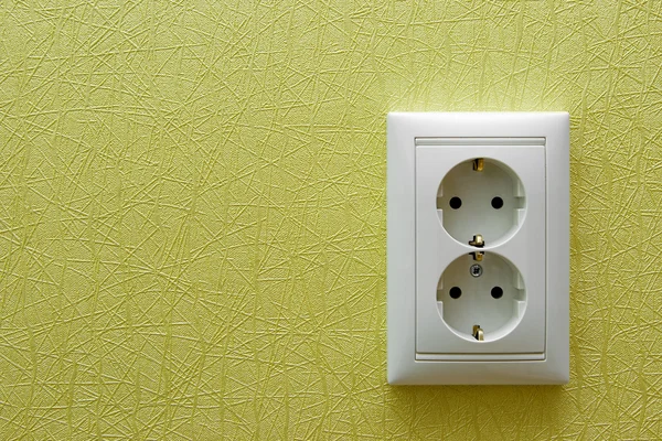Двойная электрическая розетка в зеленой стене — стоковое фото