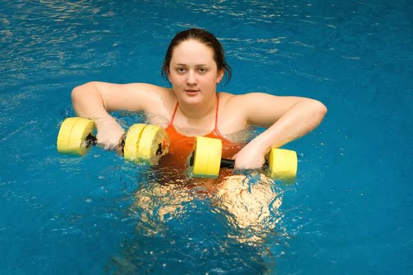 The fat woman with dumbbells in water — Stock Photo, Image