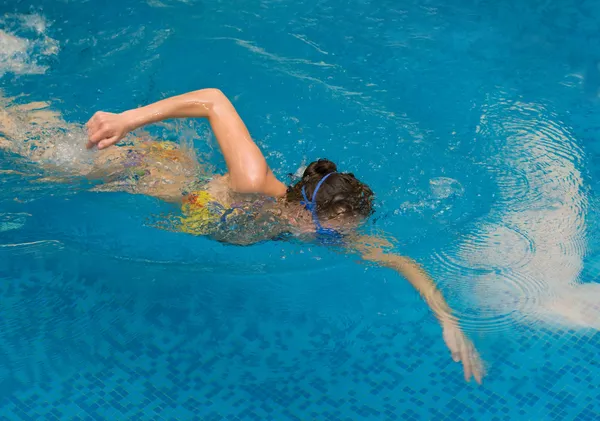 Девочка плавает в бассейне — стоковое фото
