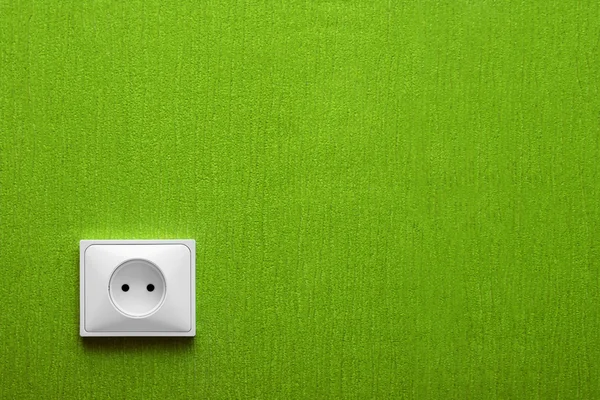 A tomada elétrica em uma parede verde — Fotografia de Stock