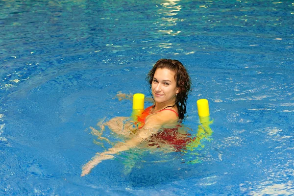 Woman is swimming on aqua noodles — Zdjęcie stockowe