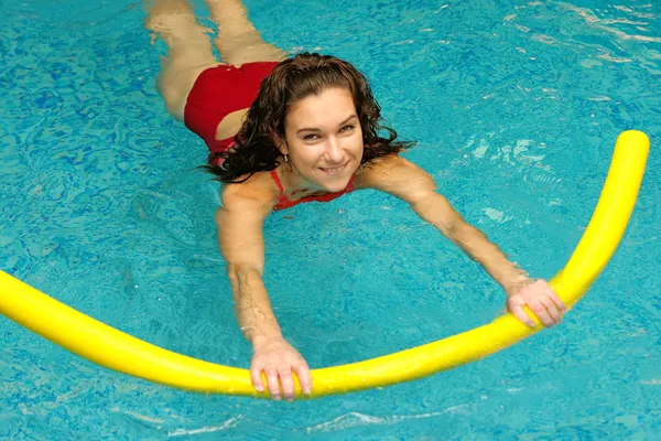 Jeune femme nage avec des nouilles — Photo