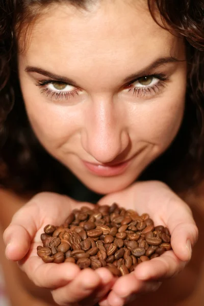 Das Mädchen hält Kaffeekörner in den Händen — Stockfoto